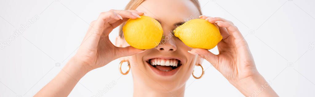 funny blonde woman posing with lemons on eyes isolated on white, panoramic shot