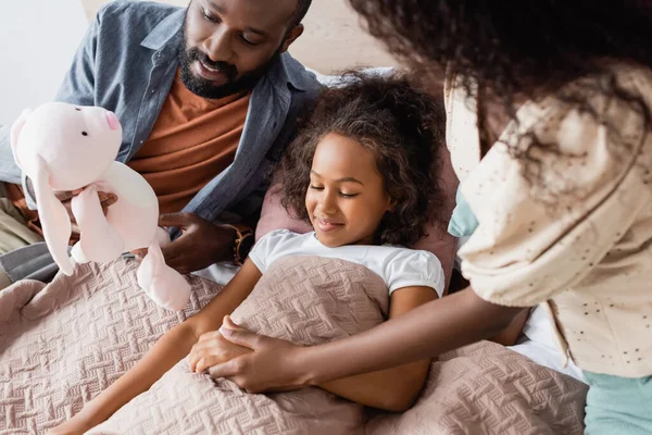 African American Man Holding Toy Bunny Daughter Lying Bed Blanket — Stock Photo, Image