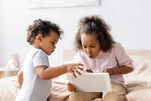 Surprised African American Girl Using Digital Tablet Little Brother Bedroom — Stock Photo, Image