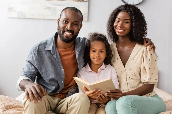 Afro Amerikalı Bir Adam Kızının Yanında Oturmuş Evde Kitap Okurken — Stok fotoğraf