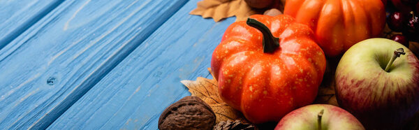autumnal harvest and foliage on blue wooden background, panoramic shot