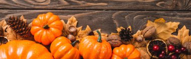 top view of autumnal decoration and pumpkins on brown wooden background, panoramic shot clipart