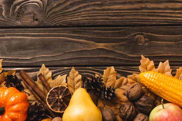 褐色木制背景的秋季收获和叶子的顶部视图 — 图库照片