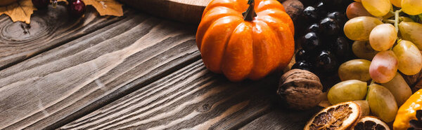 autumnal harvest on brown wooden background, panoramic shot