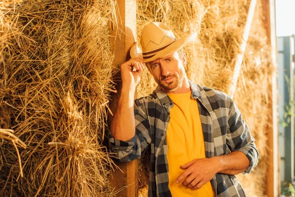 Rancher Plaid Shirt Looking Camera Touching Straw Hat While Leaning — Stock Photo, Image