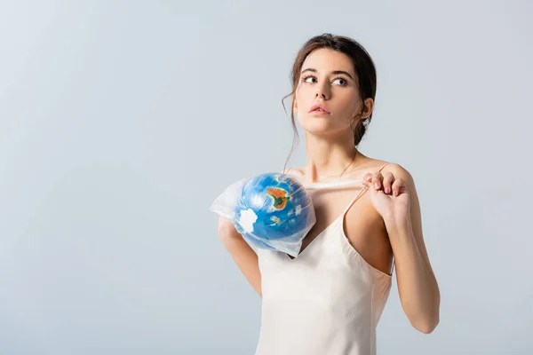Ung Kvinna Håller Plastpåse Med Jordklotet Och Tittar Bort Isolerad — Stockfoto
