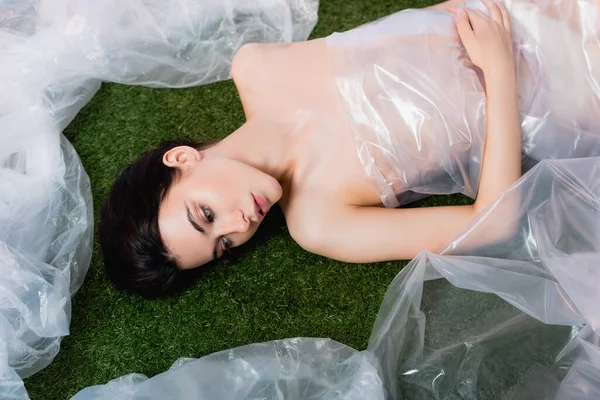 Top View Young Woman Wrapped Polyethylene Lying Grass Ecology Concept — Stock Photo, Image