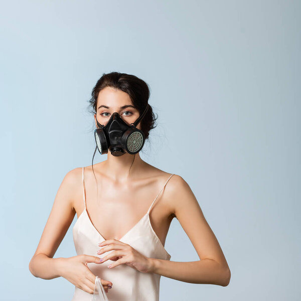 young brunette woman in gas mask holding plastic bag isolated on grey, ecology concept 