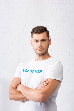 Kollarını kavuşturup kameraya bakan kendinden emin bir gönüllü. 