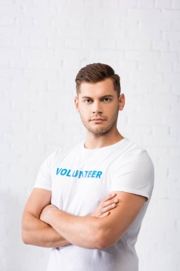 Confident volunteer with crossed arms looking at camera  clipart
