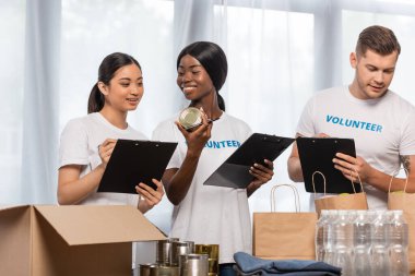 Bağış merkezindeki bağışların yanında duran çok kültürlü gönüllülerin seçici odak noktası. 