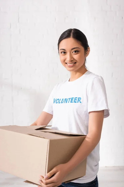 Asiatischer Freiwilliger Schaut Kamera Während Karton Hält — Stockfoto