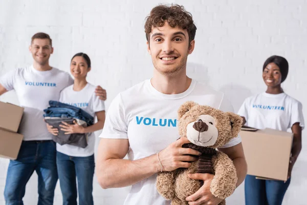 Selective Focus Man Holding Soft Toy Multicultural Volunteers Packages Charity — Stock Photo, Image