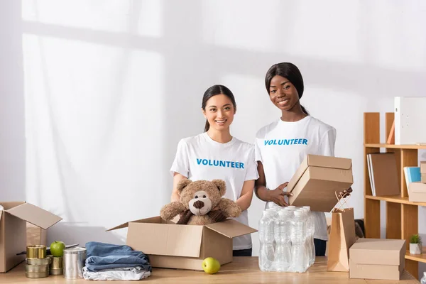 Multiethnic Volunteers Holding Soft Toy Carton Box Tin Cans Bottles — Stock Photo, Image