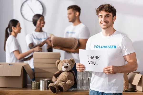 青年志愿者持卡时的选择性关注 感谢你在慈善中心给多元文化人士写信 — 图库照片