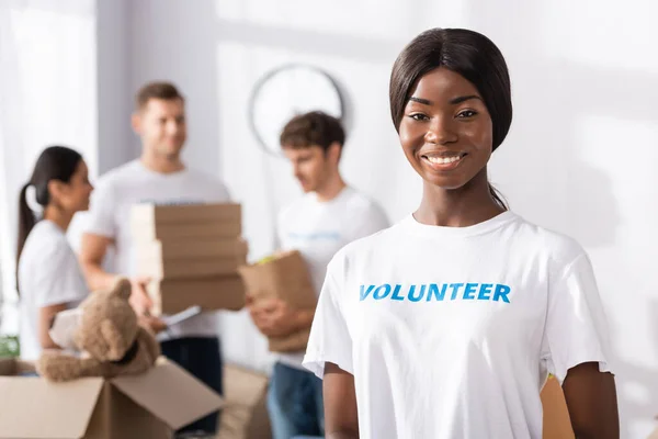 Selective focus of african american volunteer looking at camera in charity center