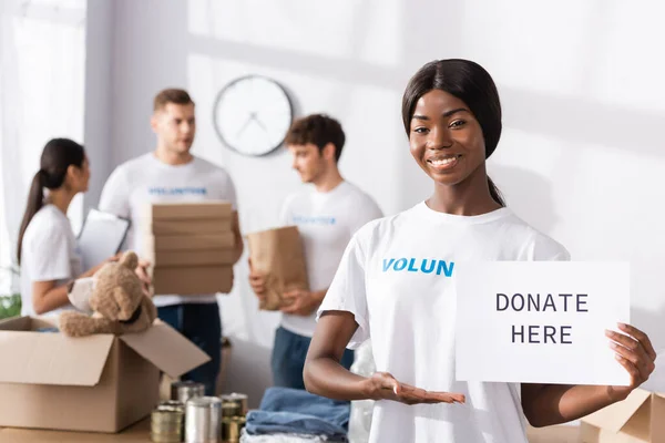 Enfoque Selectivo Del Voluntario Afroamericano Apuntando Tarjeta Con Donaciones Aquí — Foto de Stock