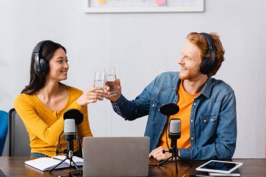 Irklar arası radyo sunucuları iş yerinde su bardaklarını tokuşturuyor.