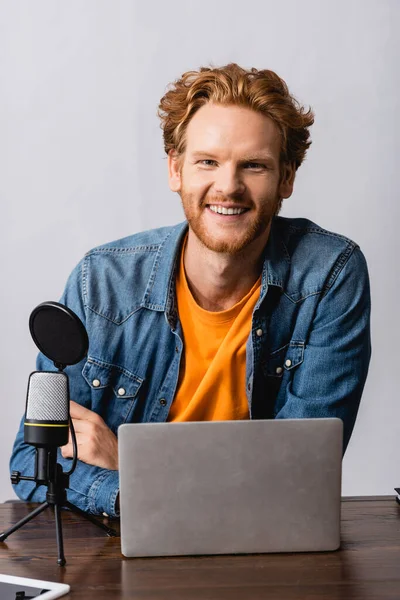 Aufgeregter Radiomoderator Jeanshemd Blickt Die Kamera Neben Laptop Und Mikrofon — Stockfoto