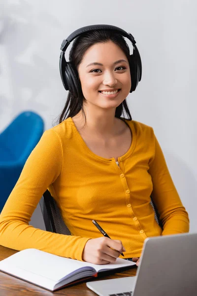 Brünette Asiatische Freiberuflerin Mit Drahtlosen Kopfhörern Die Die Kamera Schaut — Stockfoto