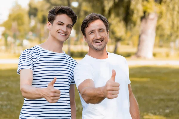 Pai Alegre Filho Adolescente Camisetas Mostrando Polegares Parque — Fotografia de Stock