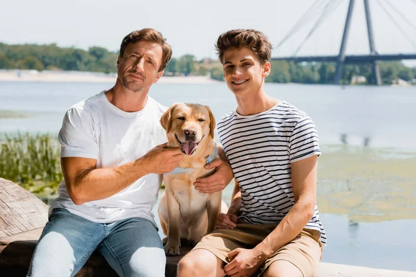Father Son Looking Camera While Sitting Lake Golden Retriever — Stock Photo, Image