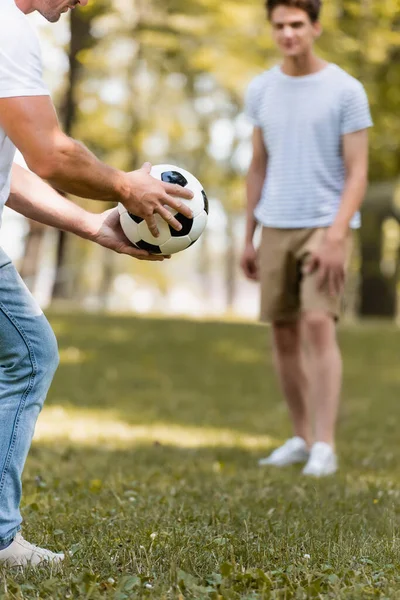 Foco Seletivo Homem Segurando Futebol Mão Perto Filho Adolescente — Fotografia de Stock