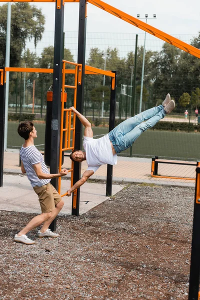 Tonårings Son Pekar Med Handen Medan Tittar Sportig Far Tränar — Stockfoto