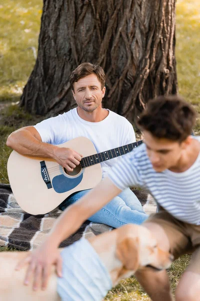 Selective Focus Father Sitting Tree Playing Acoustic Guitar While Looking — Stock Photo, Image