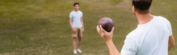 Concepto Panorámico Padre Sosteniendo Pelota Rugby Cerca Hijo Adolescente Parque — Foto de Stock