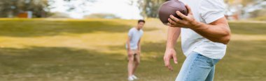 Panoramik insan hasadı parkta rugby topu oğluna atıyor. 