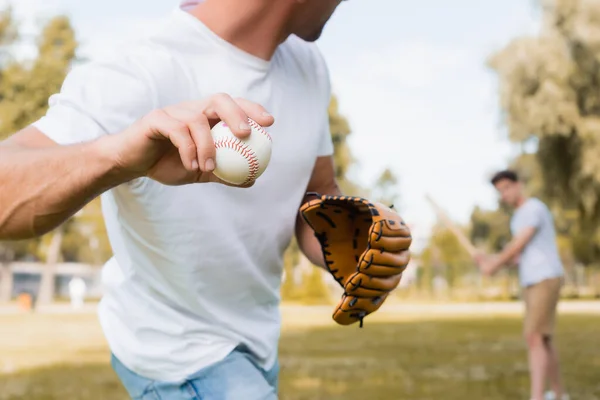 身穿皮手套的男子与十几岁的儿子在公园打棒球的剪影 — 图库照片
