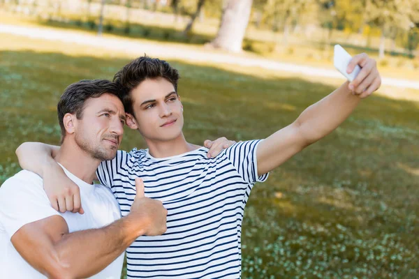 Pai Mostrando Polegar Para Cima Adolescente Filho Tomando Selfie Parque — Fotografia de Stock