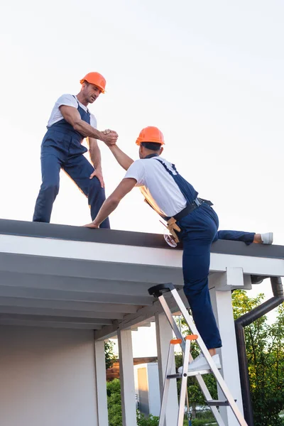 Nşaatçı Binanın Çatısındaki Merdivende Meslektaşına Yardım Ediyor — Stok fotoğraf