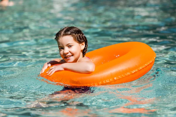 スイムリングのプールに浮かぶカメラを見て喜ぶ女の子 — ストック写真