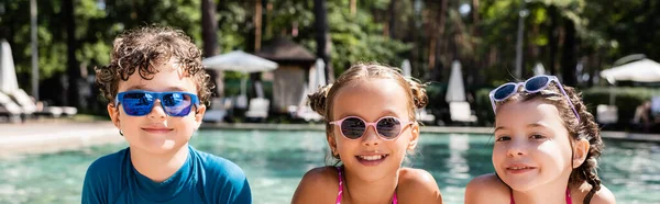 Panoramatický Záběr Chlapce Dívek Slunečních Brýlích Při Pohledu Kameru Bazénu — Stock fotografie