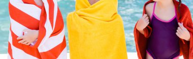 cropped view of girl in swimsuit near friends wrapping in terry towels, horizontal concept clipart