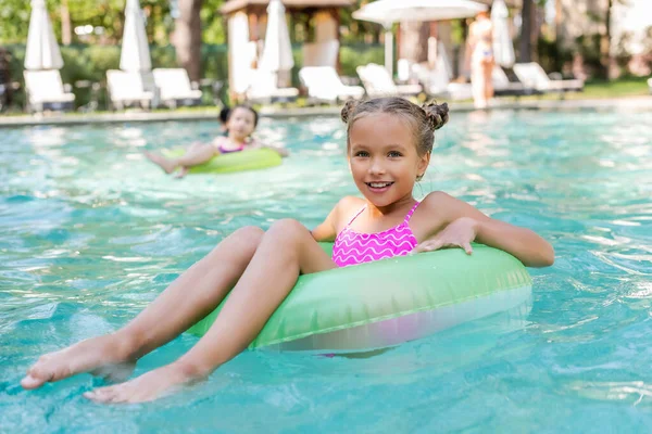 Mädchen Blickt Kamera Während Sie Pool Auf Schwimmring Schwimmt — Stockfoto