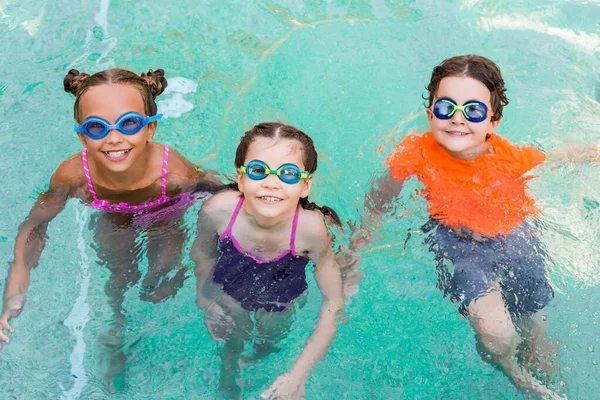 Hochwinkelaufnahme Von Mädchen Und Jungen Mit Schwimmbrille Die Die Kamera — Stockfoto