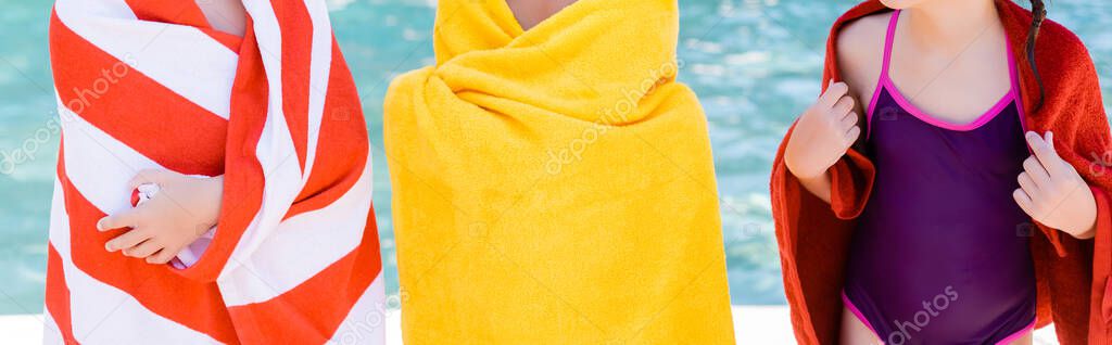 cropped view of girl in swimsuit near friends wrapping in terry towels, horizontal concept