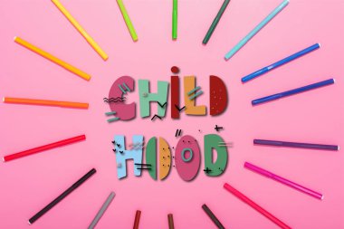 top view of frame of multicolored felt-tip pens and childhood lettering on pink  clipart