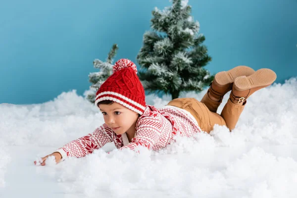 Jongen Winter Outfit Liggend Witte Sneeuw Buurt Van Kerstbomen Blauw — Stockfoto