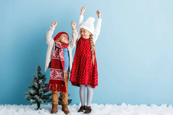 Dzieci Zimowym Stroju Rękami Nad Głowami Stojącymi Patrzącymi Siebie Niebiesko — Zdjęcie stockowe