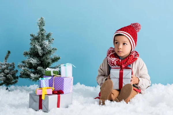 Menino Chapéu Roupa Inverno Sentado Neve Perto Presentes Árvores Natal — Fotografia de Stock