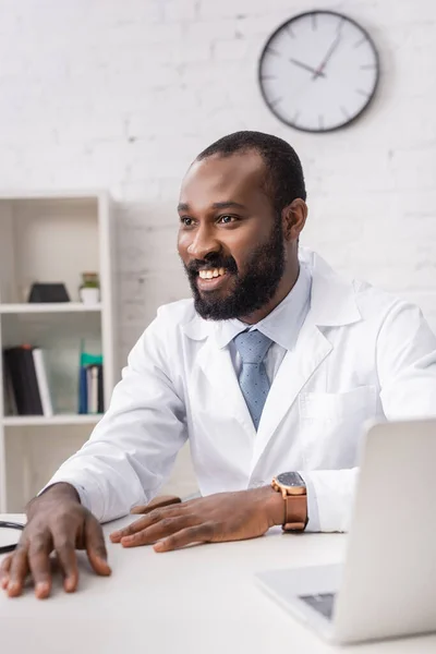 テーブルに座っているアフリカ系アメリカ人医師の選択的焦点 — ストック写真
