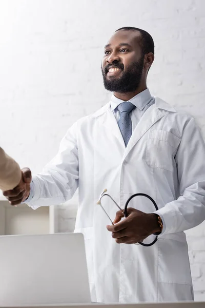 African American Doctor Holding Stethoscope Shaking Hands Patient — Stock Photo, Image