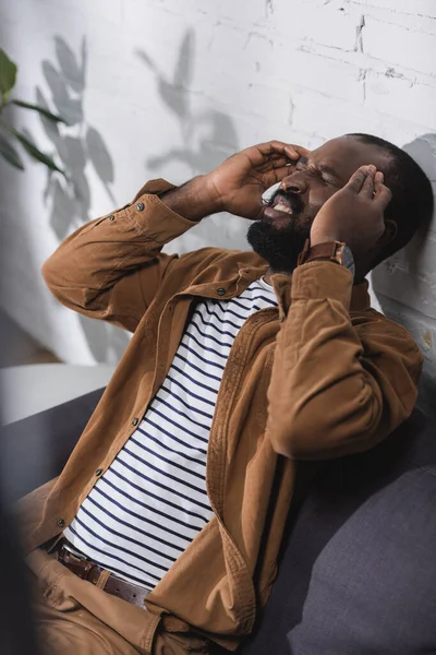 Valikoiva Painopiste Afrikkalainen Amerikkalainen Mies Istuu Sohvalla Ottaa Migreeni — kuvapankkivalokuva