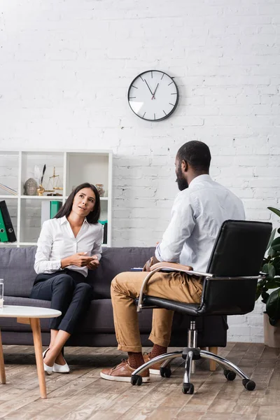 Nachdenkliche Frau Schaut Weg Während Sie Auf Dem Sofa Sitzt — Stockfoto