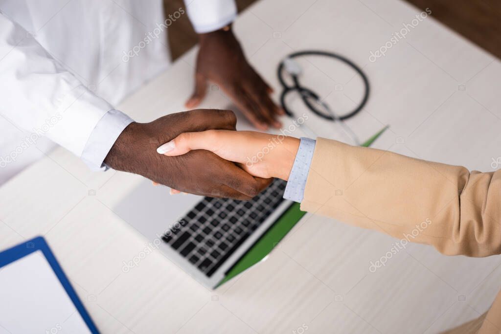 Top view of african american doctor shaking hands with patient 