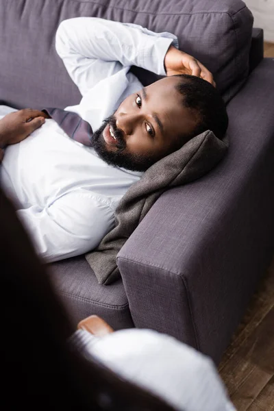 Вибірковий Фокус Афроамериканського Пацієнта Лежить Дивані Торкається Голови Біля Психолога — стокове фото